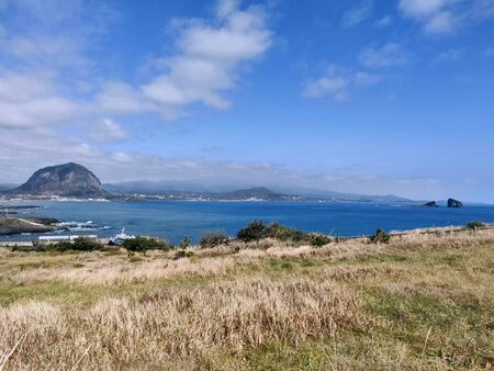 landscape view of Sanbang-san mountain and blue sea from songaksan mountain in Jeju Island, South Koreaの写真素材