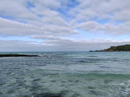 Landscape view of cobalt blue sea and cloudy sky in Hyeopjae beach with mountain and volcanic rock in Jeju Island, South Koreaの写真素材