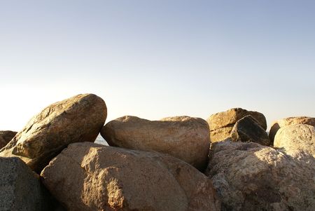 Dam made of big stones on blue background         の写真素材