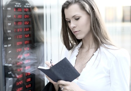 A young businesswoman is checking the currency stateの写真素材