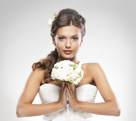 Young attractive bride with the bouquet of white rosesの写真素材