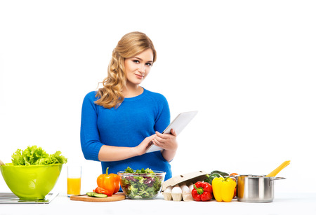 Young and beautiful housewife woman cooking in a kitchenの写真素材