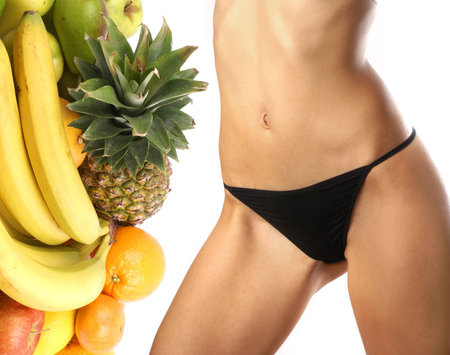 Belly of beautiful young female sportsman over dieting backgroundの写真素材
