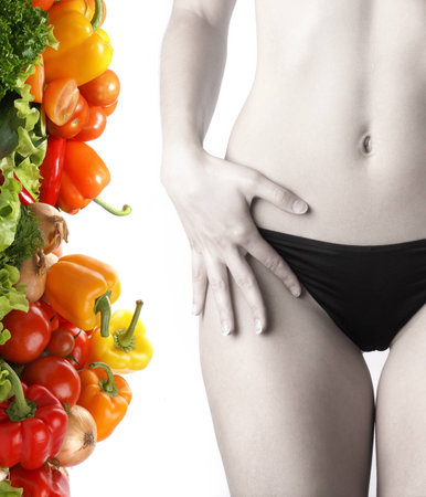 Belly of beautiful young female sportsman over dieting backgroundの写真素材