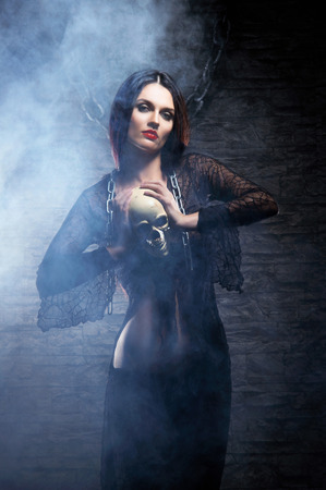 Halloween concept: young and sexy witch makes the witchcraft in the dungeonの写真素材