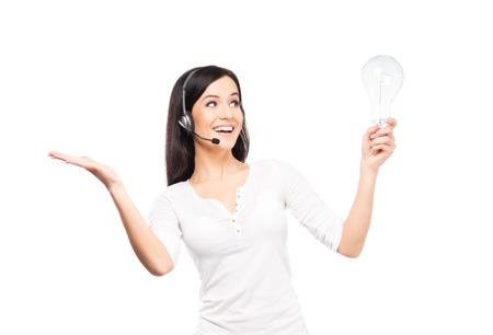Young, confident and smiling customer support operator with a bulb lamp. Idea concept.の写真素材