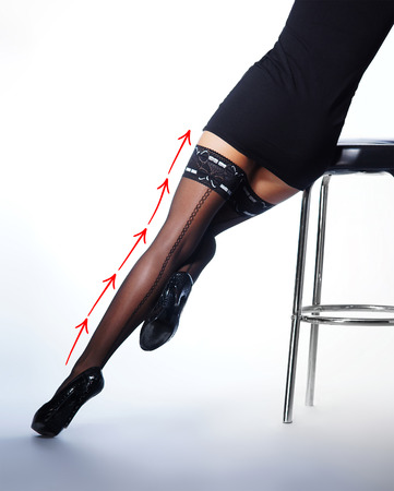 Beautiful female legs in stockings isolated on whiteの写真素材