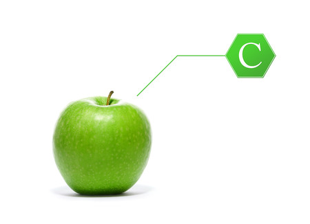 Green, fresh and tasty apple with the vitamin C pointer isolated on whiteの写真素材