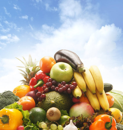 Pile of fresh and tasty fruits and vegetables over the sky backgroundの写真素材