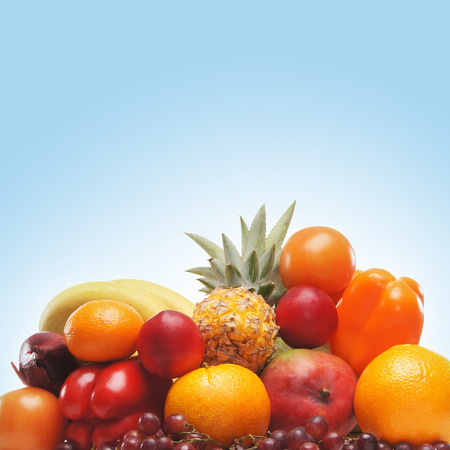 Pile of different fruits and vegetables over blue backgroundの写真素材