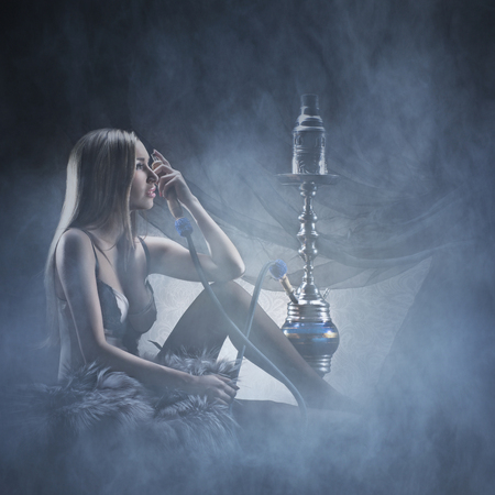 Beautiful girl in sexy underwear smoking the hookahの写真素材
