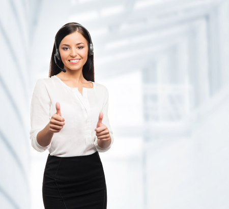 Young, confident and smiling customer support operator working in officeの写真素材