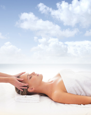 Beautiful woman is getting spa treatment over the sea and sky backgroundの写真素材
