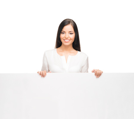 Young, confident, successful and beautiful business woman with the blank billboard isolated on whiteの写真素材