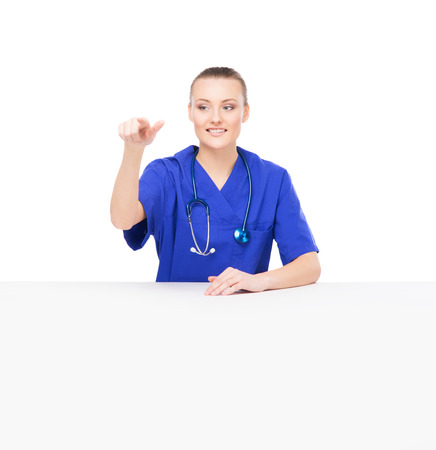 Young and professional doctor woman pushing an imaginary button isolated on whiteの写真素材