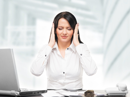 Tired and upset secretary woman working in officeの写真素材