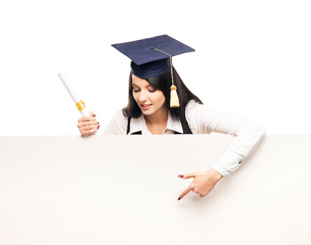 Young, beautiful and happy graduate girl with a blank banner isolated on whiteの写真素材