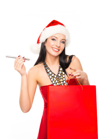 Young and beautiful Christmas shopper girl with the electronic cigarette isolated on white backgroundの写真素材