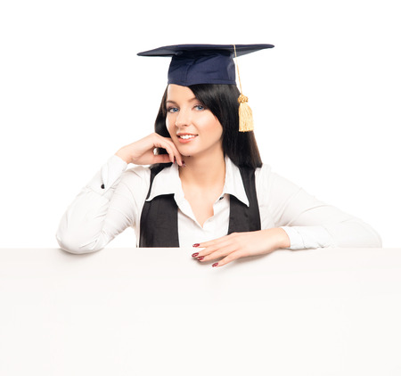 Young, beautiful and happy graduate girl with a blank banner isolated on whiteの写真素材