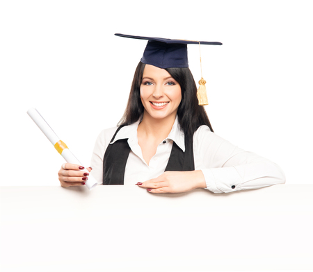 Young, beautiful and happy graduate girl with a blank banner isolated on whiteの写真素材