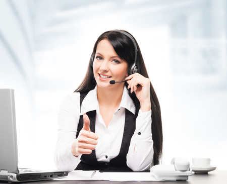 Young, confident and beautiful customer support operator working in a call centerの写真素材