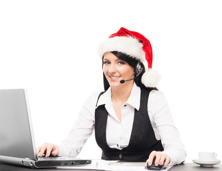 Young, confident and beautiful support operator in Christmas hat working in a call centerの写真素材
