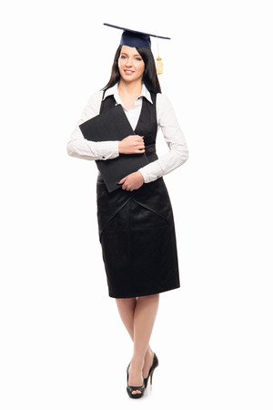 Young, beautiful and happy graduate girl holding degree diploma and smiling isolated on whiteの写真素材