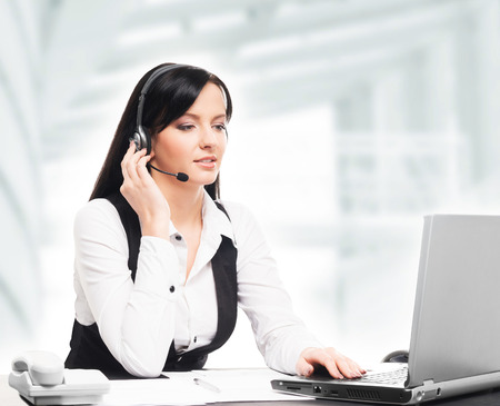 Young, confident and beautiful customer support operator working in a call centerの写真素材