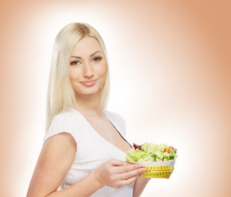 Young attractive girl with fresh and tasty saladの写真素材