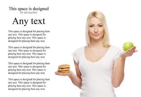 Young attractive girl making choice between healthy and harmful foodの写真素材
