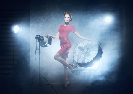 Young and emotional woman in fashion dress over glamour background (studio backstage)の写真素材