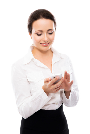 Young, confident, successful and beautiful business woman with the mobile phone isolated on whiteの写真素材