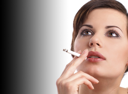 Attractive retro woman smoking over black and white backgroundの写真素材