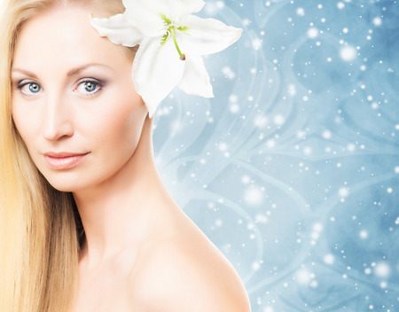 Beautiful, young and healthy girl with a fresh lily flower  over abstract backgroundの写真素材
