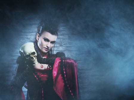 Beautiful, young and sexy female vampire over the smoky background. Halloween concept.の写真素材