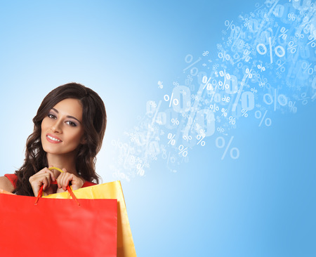 Young attractive shopper girl with the bags (discounts and sales concept)の写真素材