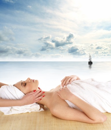 Young attractive sexy lady getting spa treatment isolated over sea backgroundの写真素材