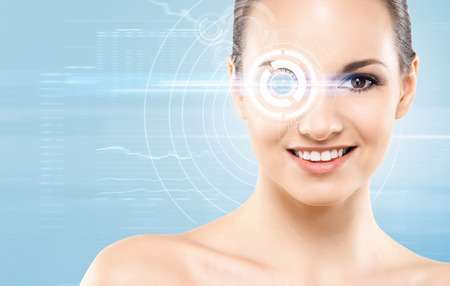 Young and attractive woman from future with the laser hologram on her eyes (collage about eye scanning technology)の写真素材