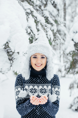 Portrait of young and beautiful girl walking in winter forest. Christmas seasonal concept.の写真素材