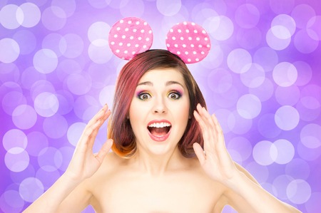 Beautiful young smiling woman in mickey mouse ears on bubble background.の写真素材