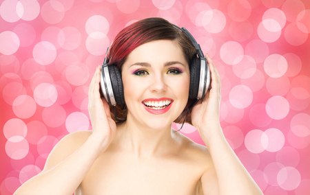 Beautiful girl listening to the music throughout headphones on bubble background.の写真素材