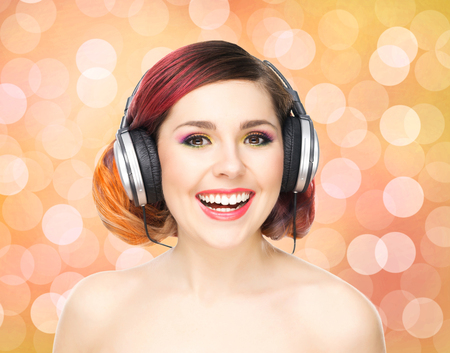 Beautiful girl listening to the music throughout headphones on bubble background.の写真素材