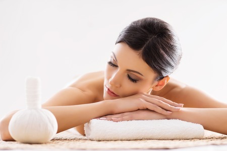 Beautiful, young and healthy woman in spa salon. Isolated on white. Spa, health and healing concept.の写真素材