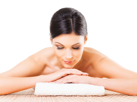 Beautiful, young and healthy woman in spa salon. Isolated on white. Spa, health and healing concept.の写真素材