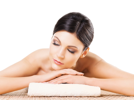 Beautiful, young and healthy woman in spa salon. Isolated on white. Spa, health and healing concept.の写真素材