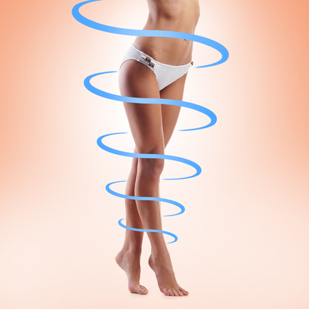 Close-up of thin and beautiful female body. Weight loss, sports, exercising, water balance, healthy nutrition concept. Blue arrows.の写真素材
