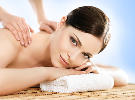Young and beautiful girl relaxing in Christmas spa salon. Massage therapy, healing medicine and health care concept.の写真素材