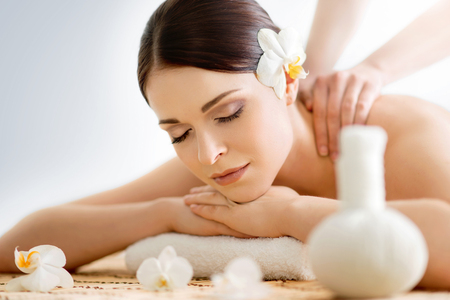 Beautiful, young and healthy woman in spa salon. Massage treatment, traditional medicine and healing concept.の写真素材