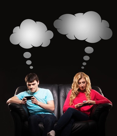 Young man and woman more interested in playing mobile games rather than socialising. Comics concept.の写真素材
