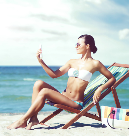 Beautiful and sexy woman in bikini relaxing on beach. Traveling, holiday, vacation concept.の写真素材